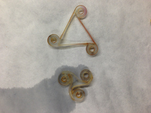 Auxetic shape memory polymer that has been compressed to its “closed” position (object on the bottom) from its “set” position (object on the top).